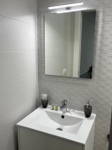 a white bathroom with a sink and a mirror at Truly Apulia in Bari