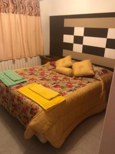 Una cama con sábanas amarillas y almohadas. en Vientos del Sur en Río Gallegos