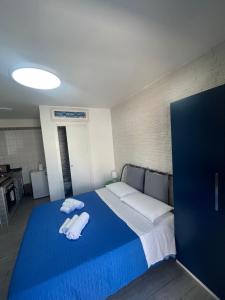a bedroom with a blue bed with towels on it at Truly Apulia in Bari