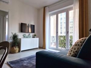 uma sala de estar com um sofá, uma televisão e uma janela em Quick Flat - Milan Central em Milão