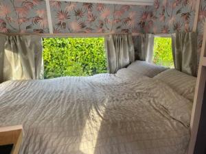 uma cama num quarto com uma janela em Molly The Vintage Caravan. em Wigton