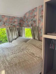 - une chambre avec un lit avec une tête de lit dans l'établissement Molly The Vintage Caravan., à Wigton