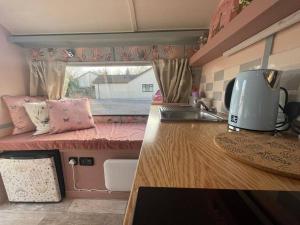 a kitchen with a counter and a sink in a caravan at Molly The Vintage Caravan. in Wigton