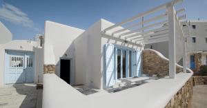 a white house with a staircase leading up to it at Mimosa Retreat Mykonos in Ornos