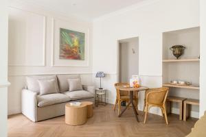 una sala de estar con un sofá y una mesa en Mylu Suites by Puerta Catedral, en Sevilla