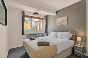 Un dormitorio con una cama grande y una ventana en Lovely 3-Bed Clapham Common en Londres