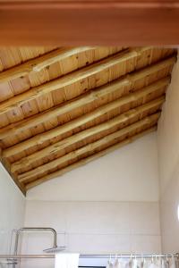 a ceiling in a bathroom with wooden beams at Casas Goulart in Canto da Areia