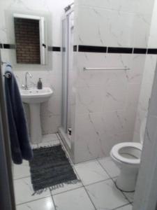 Un baño blanco con inodoro y lavabo. en Linga Longa, en Beaufort West 4 fotos más
