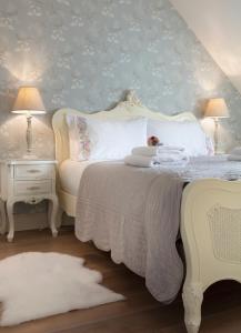 1 dormitorio con cama blanca y pared azul en Shrubbery Mews Luxury Apartment, en Kenmare