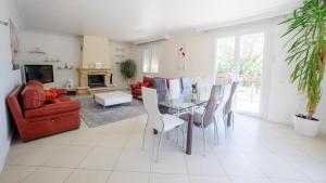 een woonkamer met een glazen tafel en stoelen bij Villa de vacances moderne à côté de Bergerac in Prigonrieux