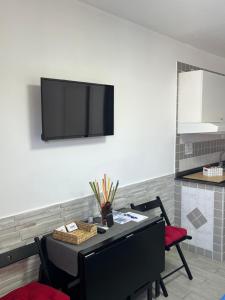 a room with a table with chairs and a tv on the wall at Truly Apulia in Bari