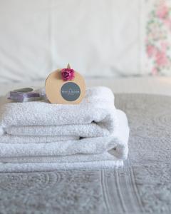 una pila de toallas sentadas encima de una cama en Shrubbery Mews Luxury Apartment en Kenmare