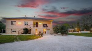een groot huis met een zonsondergang op de achtergrond bij Villa de vacances moderne à côté de Bergerac in Prigonrieux