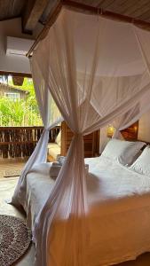 um quarto com uma cama e uma rede mosquiteira em Pousada Hayo Pé na Areia em Caraíva