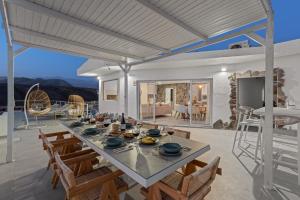 a dining room and living room with a table and chairs at KARAT Villa Punta Rasca in Palm-mar
