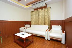 a hospital room with two beds and two chairs at Kovilakam Residency in Trichūr
