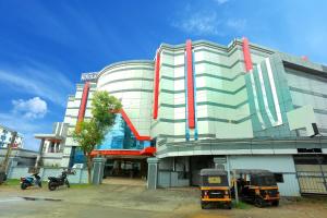 a building with two tractors parked in front of it at Kovilakam Residency in Trichūr