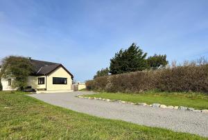 une petite maison avec une route en gravier devant elle dans l'établissement 3 Bed Detached Cottage- Log Burner Mountain Views, à Beaumaris