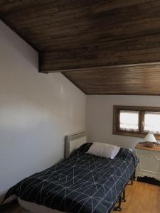 - une chambre avec un lit et un plafond en bois dans l'établissement Casa Txillarenea, à Igantzi