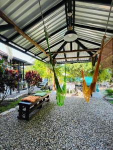 un patio con banco y hamacas bajo un techo en AnaGris Cottage, en Monterrey