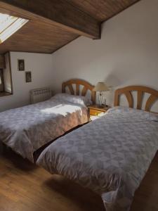 ein Schlafzimmer mit 2 Betten und einem Tisch mit einer Lampe in der Unterkunft Casa Txillarenea in Igantzi