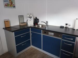 a kitchen with blue cabinets and a sink at Burgapartment Esselsturm in Monschau