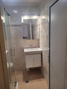 a bathroom with a white sink and a shower at Sozopoli Hills, app B7 in Sozopol
