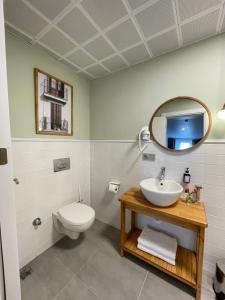 a bathroom with a sink and a toilet and a mirror at Meshk Airport Hotel in Arnavutköy