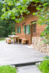 a wooden building with a picnic table and benches at Almhaus Webermohof in Rottach-Egern