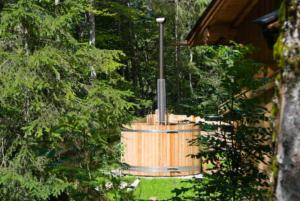 - un bain à remous en bois dans la cour d'une maison dans l'établissement Almhaus Webermohof, à Rottach-Egern