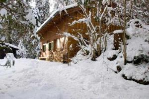 une maison recouverte de neige devant dans l'établissement Almhaus Webermohof, à Rottach-Egern