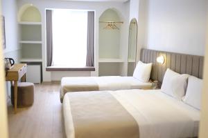 um quarto de hotel com duas camas e uma janela em Meshk Airport Hotel em Arnavutköy