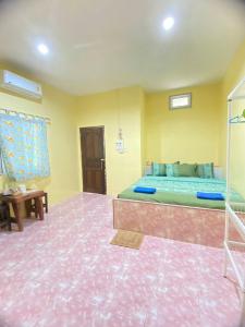 1 dormitorio con 1 cama y suelo de color rosa en At Sichon Resort en Sichon