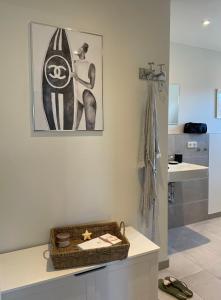 a bathroom with a sink and a surfboard on the wall at Ferienwohnung Dünenbutze in Büsum