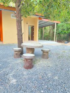 a picnic table next to a tree next to a building at At Sichon Resort in Sichon