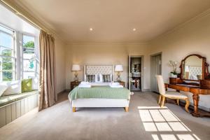 a bedroom with a bed and a desk and a piano at The Black Lion, Long Melford in Long Melford