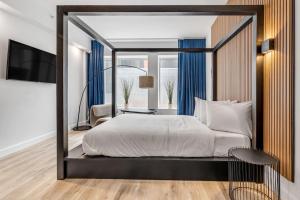 1 dormitorio con 1 cama grande y TV en Initial / Libre / Centre-ville de Quebec en Quebec