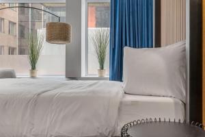 1 dormitorio con cama blanca y ventana en Initial / Libre / Centre-ville de Quebec en Quebec