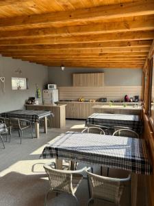 a room with tables and chairs and a kitchen at Vila Palade in Corbu