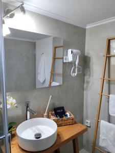 a bathroom with a white sink and a mirror at Nini's Houses in Nydri