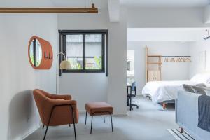 a bedroom with a bed and a chair and a window at Tabas - Ed. Magdalena Laura - Vila Buarque in São Paulo