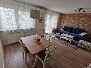 a living room with a table and a blue couch at Višnja-Ravnice in Zagreb