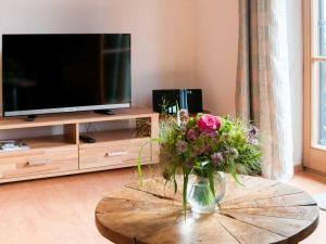 Una sala de estar con una mesa con un jarrón de flores. en Ferienwohnungen Nutz, en Bad Wiessee 40 fotos más