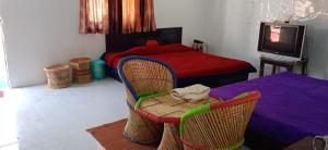 a bedroom with a bed and a table and chairs at Silver Dew Resorts and Restaurant in Dhanaulti