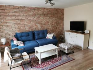 uma sala de estar com um sofá azul e uma parede de tijolos em Višnja-Ravnice em Zagreb
