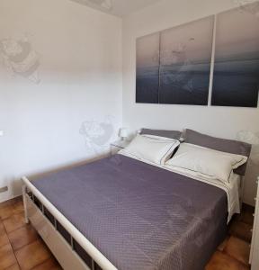1 dormitorio con 1 cama grande con sábanas moradas en Mamma Mia, en Marina di Ginosa