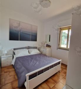 Un dormitorio con una cama grande y una ventana en Mamma Mia, en Marina di Ginosa