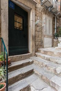 a black door with stairs in front of a house at Guest House Tomasi in Dubrovnik