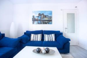 Sofá azul en la sala de estar con mesa en El Mirador de Mundaka by Urdaibai Rentals, en Mundaka