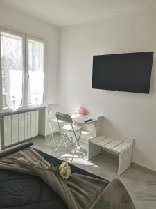 a white living room with a tv on the wall at LONATE ROOM in Lonate Ceppino